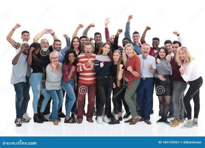 a group of people standing next to each other in front of a white wall